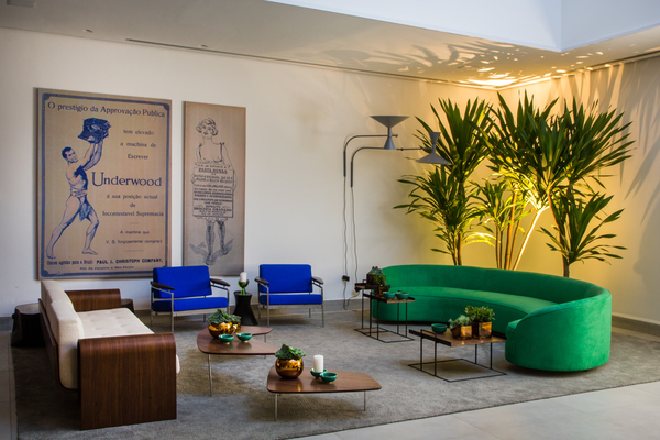 CASACOR Rio de janeiro 2015. Foyer da Villa - Jimmy Bastian Pinto. Predominam o verde e o azul das praias e lagoas cariocas, neste espaço que é meio lobby de hotel, meio galeria, repleto de referências à história da cidade e ao bom humor local. A história do Rio é contada nas capas e anúncios da Revista Careta, dos primeiros anos da República, e no mobiliário modernista dos anos 1950 e 1960, em peças do designer Sérgio Rodrigues e do arquiteto Oscar Niemeyer.