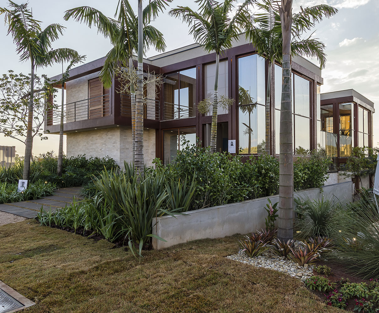 <span>Fachada da Casa Bossa Nova - Izilda Moraes. O aço corten predomina no revestimento, mas o material recebeu tratamento para resistir à corrosão, tanto nos pilares como nas vigas. Algumas paredes externas foram cobertas de pedras, da Palimanan. Um piso drenante foi aplicado na fachada e no entorno. O deck é de pinus autoclavado, enquanto a madeira de reflorestamento foi utilizada na área de estar. O jardim abriga espécies nativas, desenvolvido pelo paisagista Alexandre Galhego.</span>