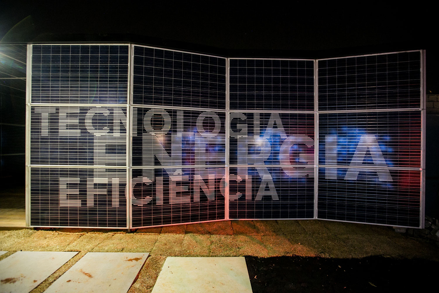 CASACOR Minas Gerais 2016. OptPower, por Silvio Todeschi, Ana Bahia e Mariana Hardy. Situado dentro de um container, o espaço é responsável por toda a energia usada na CASA COR Minas - gerada através da captação dos raios solares e fornecida pela empresa OptPower. Os profissionais exploraram o uso dos próprios painéis de energia fotovoltaica para envelopar e revestir toda a estrutura do ambiente. No seu interior, está localizado o maquinário que distribui a eletricidade para a sede e a fachada recebeu um trabalho tipográfico e um videowall informando sobre a tecnologia e o produto utilizado.