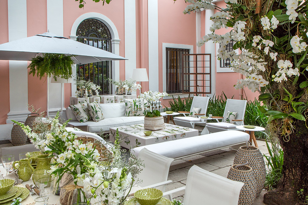 CASACOR Rio de Janeiro 2016. Estar do Jardim - Bebel Niemeyer e Maria Pia Marcondes Ferraz. A sala de jantar tem mesa Seax, de Jean Marie Massaud para Dedon, acompanhada de cadeiras de Toan Nguyen e Massaud, com objetos Tânia Bulhões. O estar também traz móveis assinados, como o sofá Rayn de Phillipe Starck. A mesa de centro é um projeto de Bebel e Maria Pia com a artista Viannita Barcelos, que trabalha com azulejaria e criou o desenho exclusivo. A padronagem casa com as almofadas, com tecidos da Ipanema Kravet.