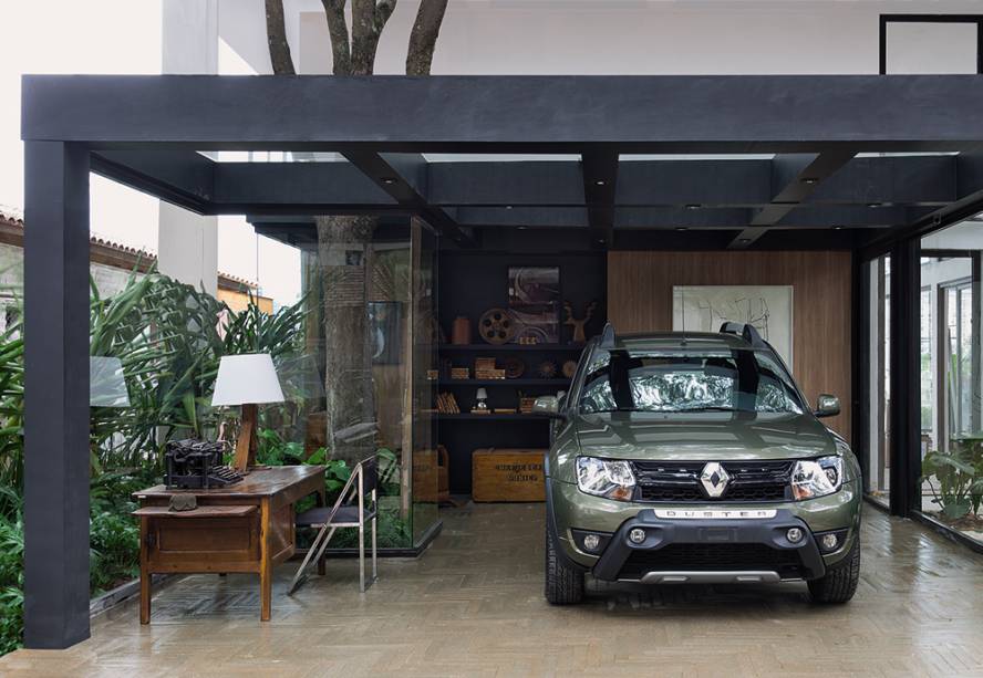 CASACOR São Paulo 2016. Casa com Garagem Renault - Ana Maria Vieira Santos. A arquiteta projetou uma morada de 160 m² com todos os confortos modernos, que se destaca pela integração com a natureza através das grandes aberturas de vidro Ultaclear. Uma das árvores existentes no local, inclusive, foi incorporada e envolvida por uma coluna do mesmo material que também incorpora a estrutura do mezanino e da garagem, transformando o local de estacionamento do carro em uma vitrine.