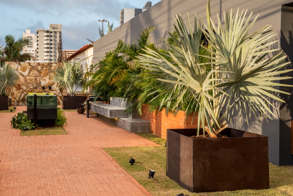 <span>Elemental Garden - Michelle Viana. A imensa placa em mármore, com um desenho único, impacta ao primeiro olhar. O espaço também traz um quê de brutalismo, com o banco em pedra e as formas retilíneas. As plantas se moldam ao redor, nesta sala ao ar livre.</span>