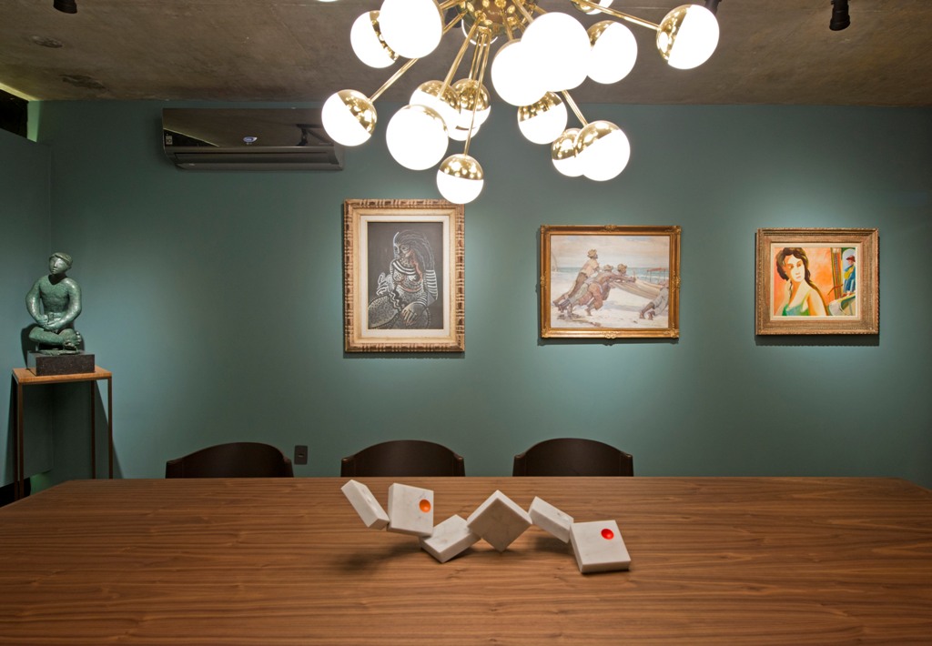 Sala de Jantar do Colecionador - Rodrigo Porto. O luxo do século 21 valoriza o minimalismo e o essencial. Daí vem a simplicidade do teto em concreto aparente e da cartela de cores comedida, em verde e rosa. A iluminação de baixa intensidade foca em áreas de interesse - bom exemplo é o lustre da designer brasileira Ana Neute, acima da mesa de jantar de Jader Almeida.