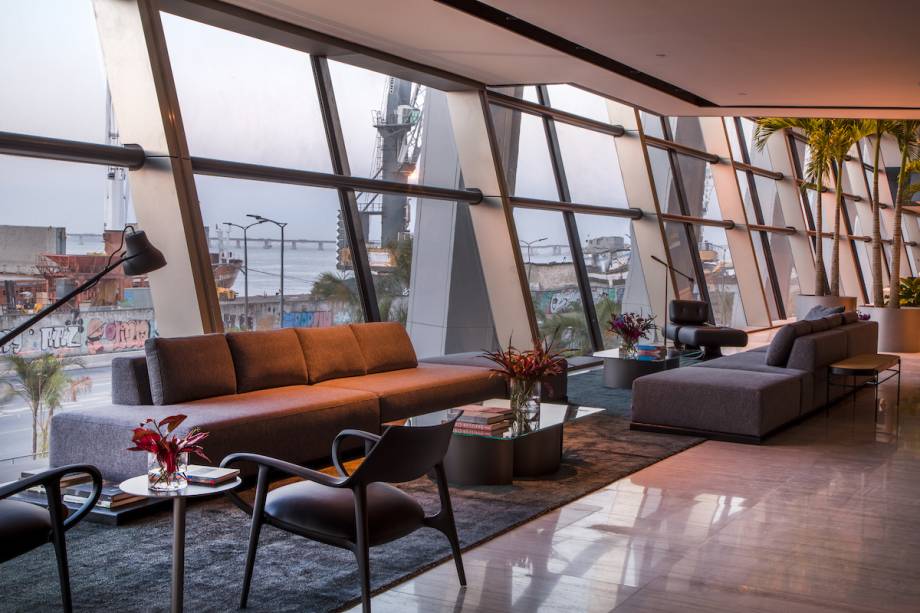 CASACOR RJ. Lobby – Gisele Taranto. Nesse espaço, os elementos brasileiros são foco: as pedras exóticas brasileiras no piso e nas paredes se somam ao mobiliário de design de grandes nomes. Destaque para Poltrona Alta com banqueta e marquesas de Oscar Niemeyer, mesa de centro Arcos e laterais Ciranda, de Ricardo Fasanello, sofás Bow, de Bruno Faucz e poltronas Dora e Celine, de Jader Almeida.