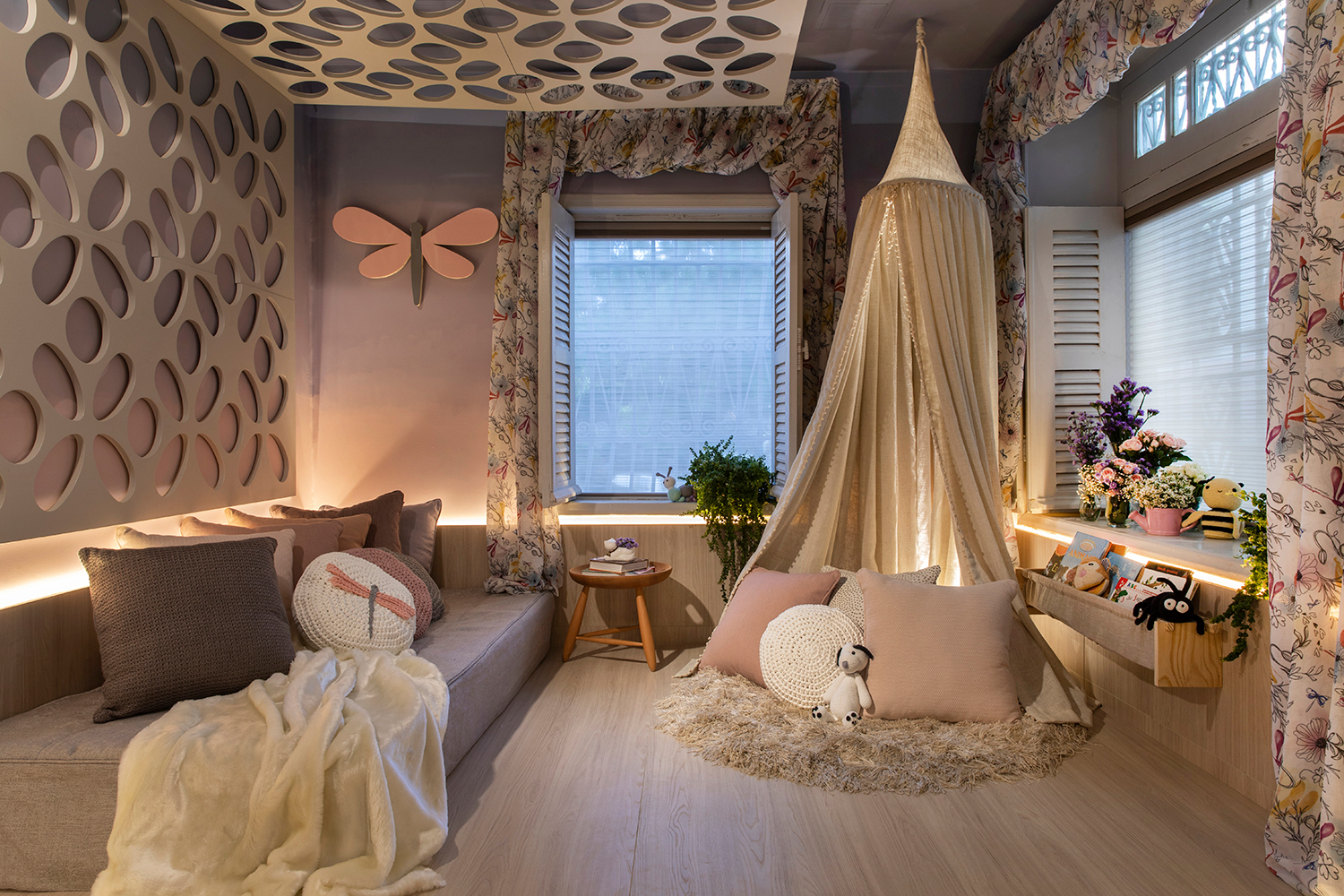 Quarto da Menina - Arquiteturassim. Para inspirar os sonhos da menina, um ambiente suave em tons românticos. A iluminação é diluída pelos painéis de madeira que abraçam o lugar. Outro elemento importante é o painel com recortes em forma de flores, que se prolonga até o teto. A tenda convida a ler, brincar e criar um universo particular.