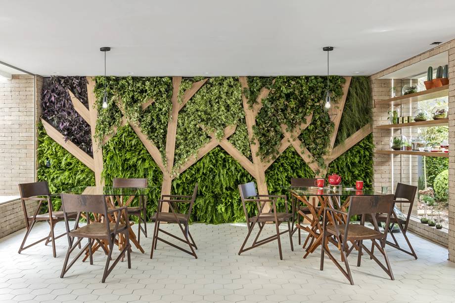 CASACOR São Paulo 2018. Tea Lab - SP Arquitetura. Tiras de madeira representam troncos de árvores, enquanto espécies como samambaias, guaimbês, columeias e tradescantias completam a paisagem verde. A estrutura do jardim vertical foi montada com barras de alumínio, placas e mantas duplas de alta densidade, nas quais as mudas foram implantadas em bolsos abertos. Toda a irrigação e fertilização é automatizada.