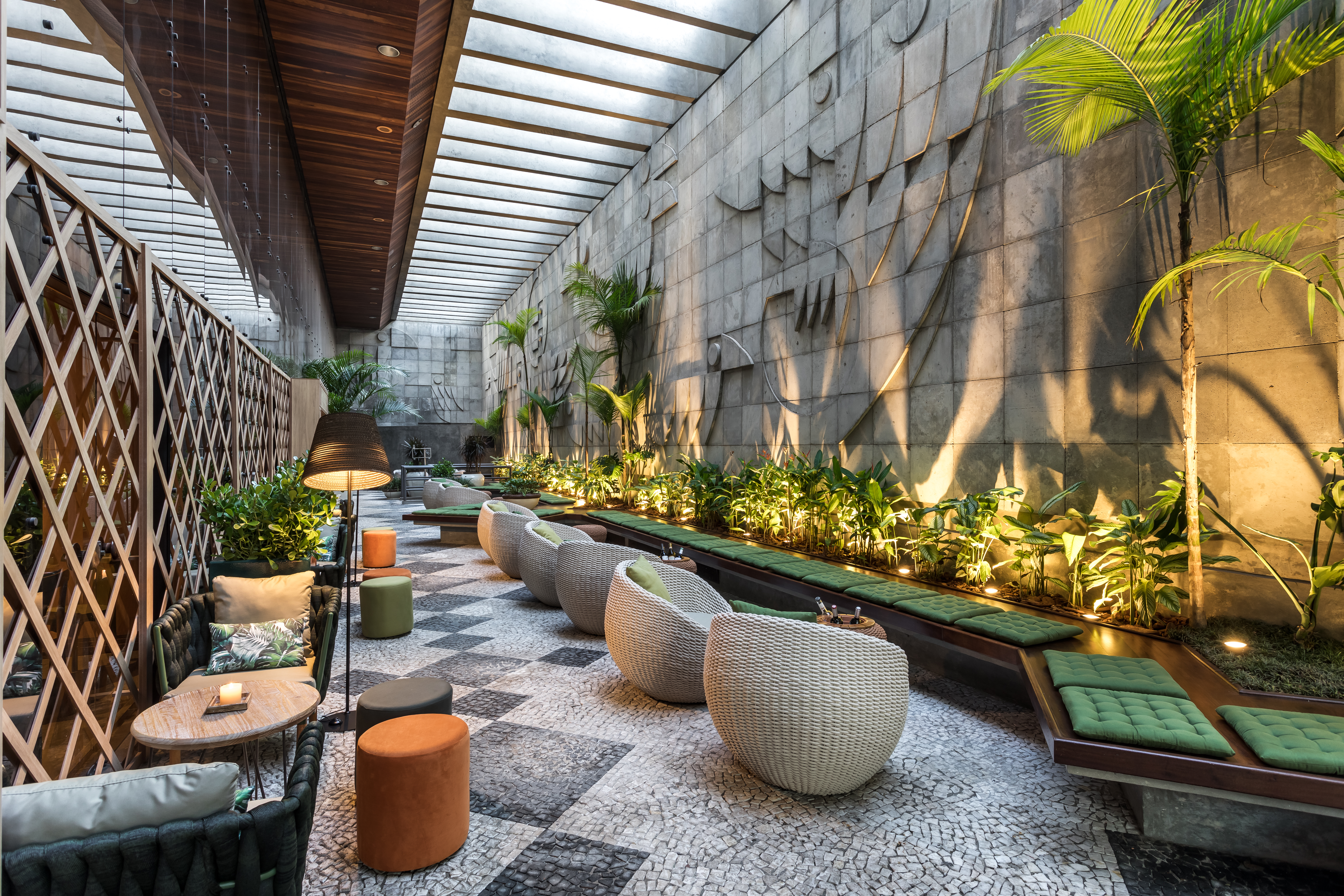 Praça Zoller - Viviane Tabalipa. Madeira e cimento são as texturas predominantes neste espaço de convivência, que apoia o Café Boutique também assinado pela profissional. O painel desenvolvido pelo arquiteto Ricardo Amaral ganha ainda mais evidência com o projeto luminotécnico, que complementa os pergolados originais da praça.