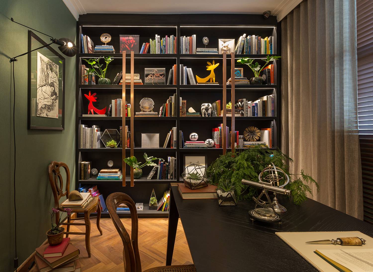 CASACOR São Paulo 2016. Home Office - Patricia Hagobian. O ambiente conta com bastante luz natural, mas não abre mão de um projeto de iluminação com foco nas obras de arte e na mesa de trabalho. A estante repleta convida à leitura.