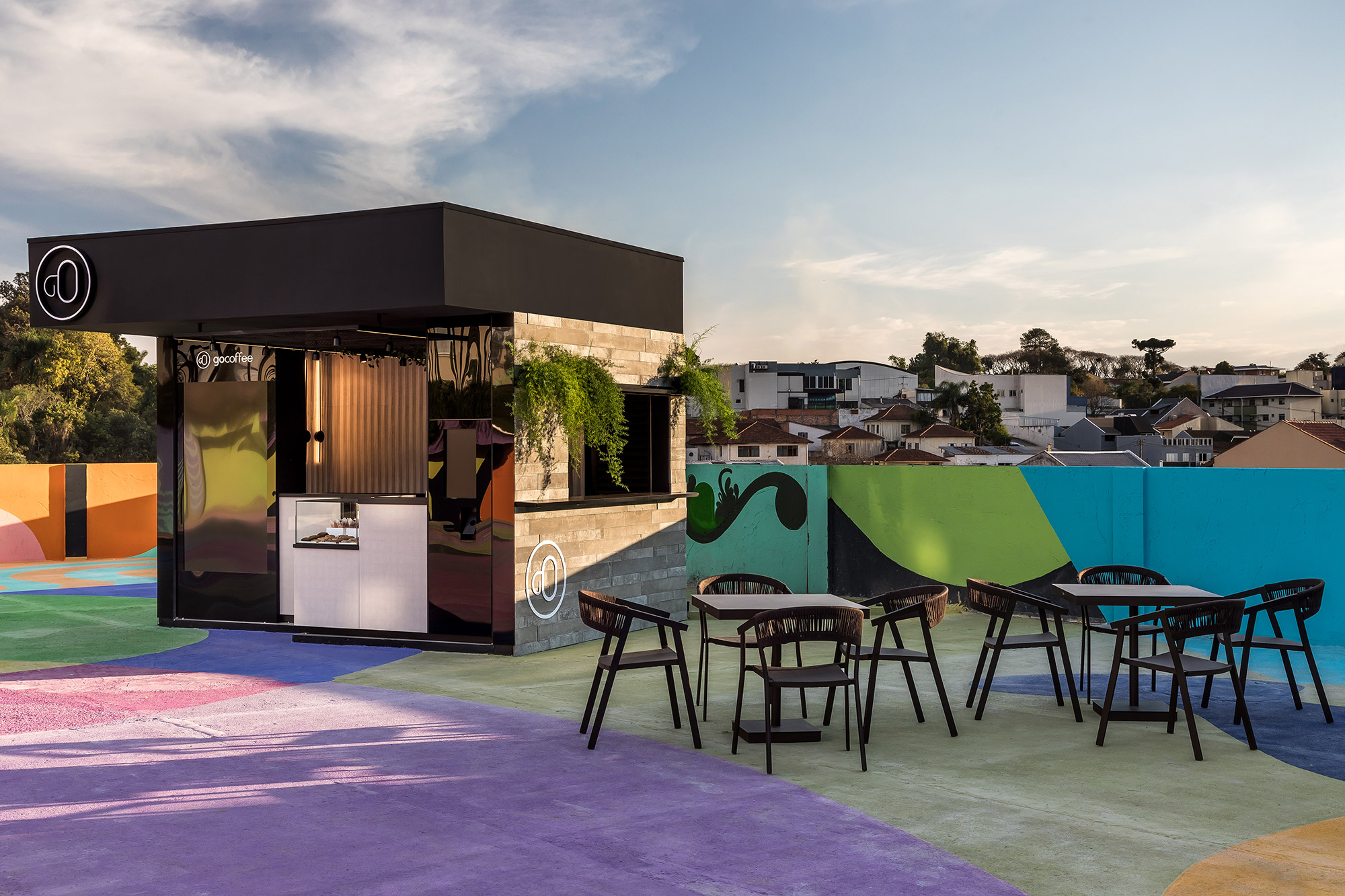 André Henning - Cafeteria. Aparecendo como uma inserção urbana no meio da praça, o projeto conversa com o público que está de passagem, proporcionando uma pausa. Por meio das formas ortogonais e pelo uso de materiais como as placas de concreto aparente, metal preto, perfis de led e painéis de comunicação visual, o ambiente busca expressar os traços da cidade contemporânea, criando um espaço instagramável.