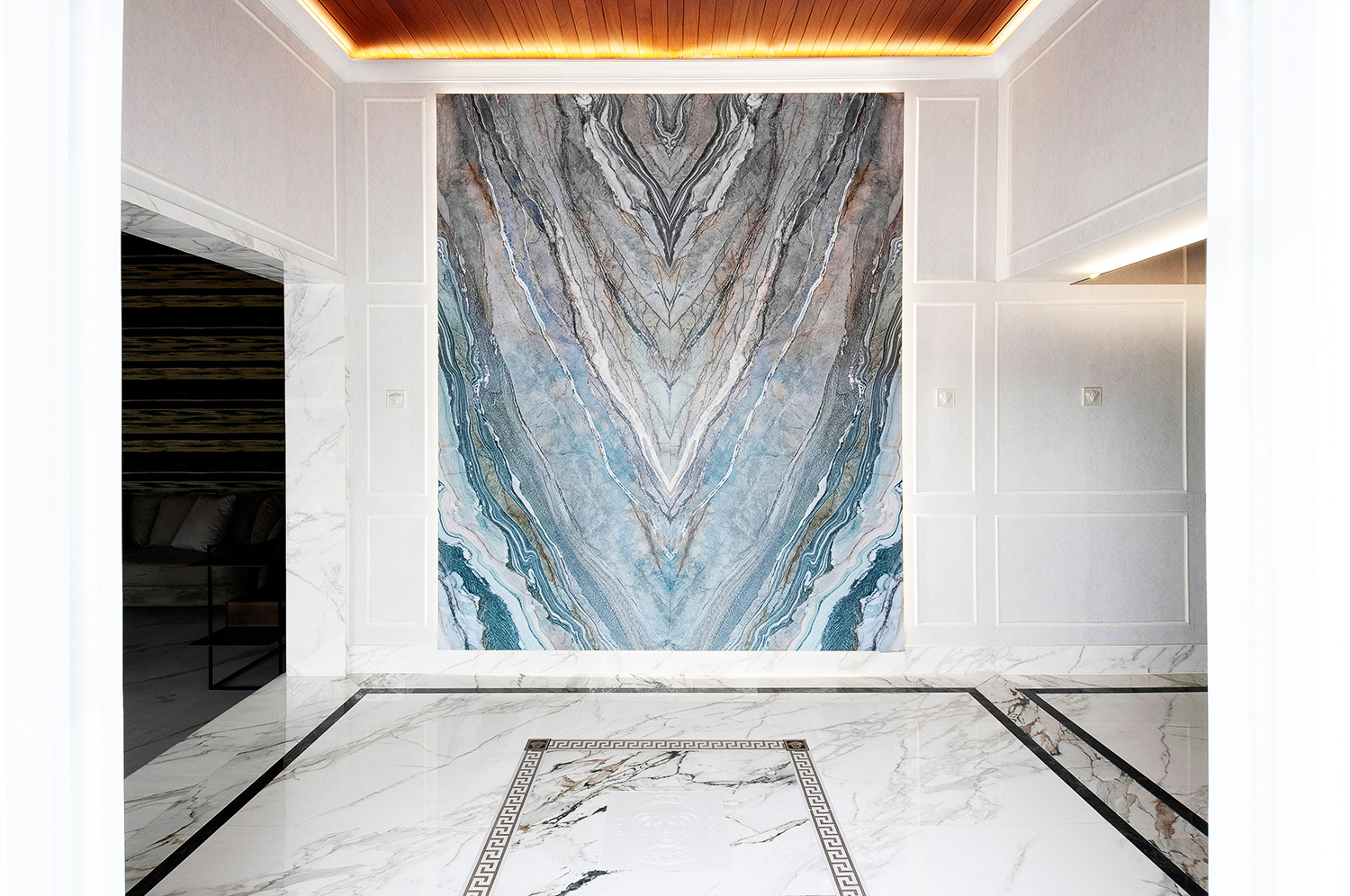 Daniel Raygada - Lobby Versace. No Versace Lobby materializamos um conceito nunca antes visto no Peru, alcançamos a simbiose mágica entre a elegância italiana e as cores da natureza, transformando o espaço em uma mistura de luxo e misticismo. A sutileza do bege e o imponente verde lembram a casa de Gianni Versace: as praias da Calábria; enquanto o banheiro se torna uma ode à feminilidade e força de Donatella para continuar seu legado, vendo-se refletida na resiliência da água-viva grega e na elegância do ouro europeu.