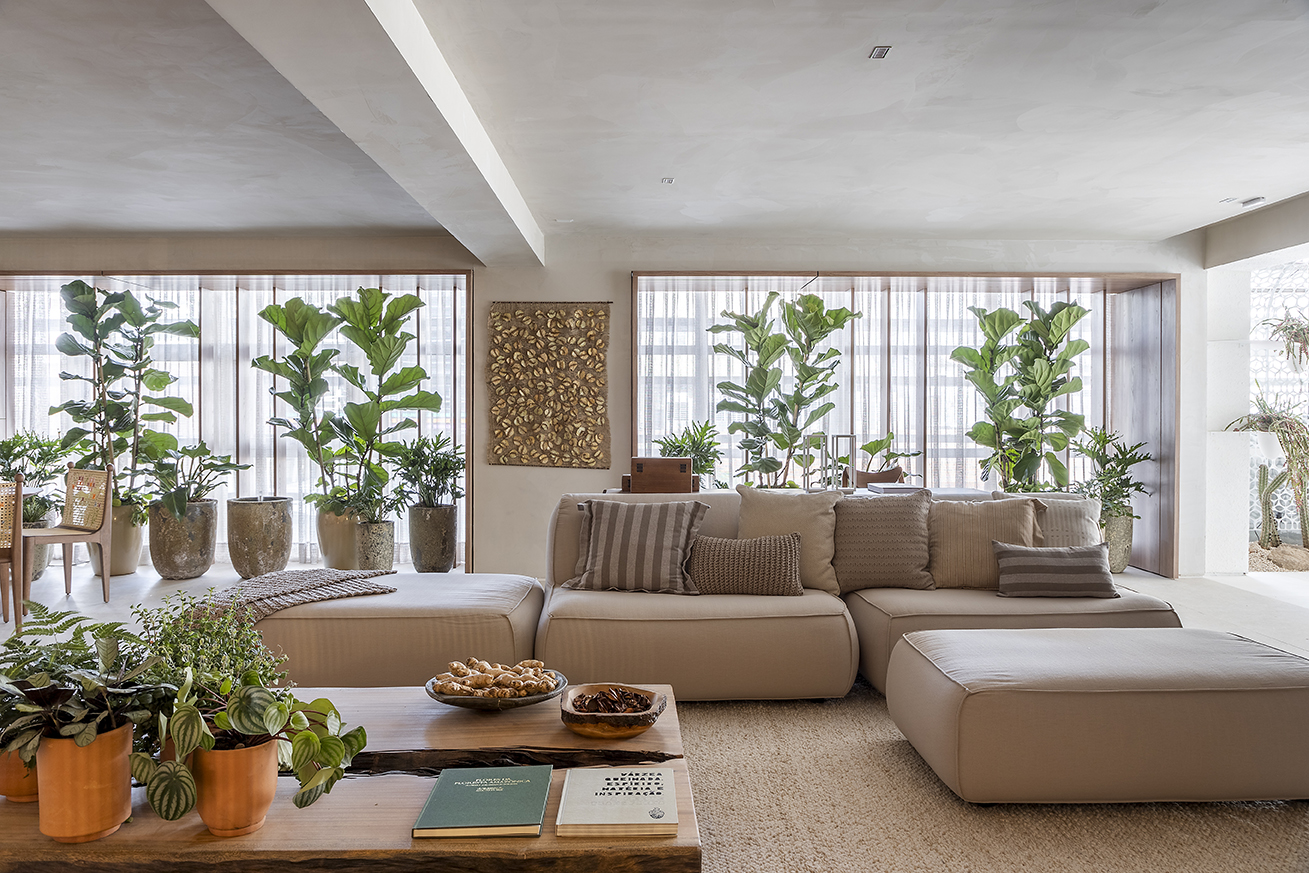 Isabella Nalon Arquitetura e Interiores - Refúgio Conexão. Projeto da CASACOR São Paulo 2023. Na foto, sala de estar com sofa em L, plantas, mesa e tapete.