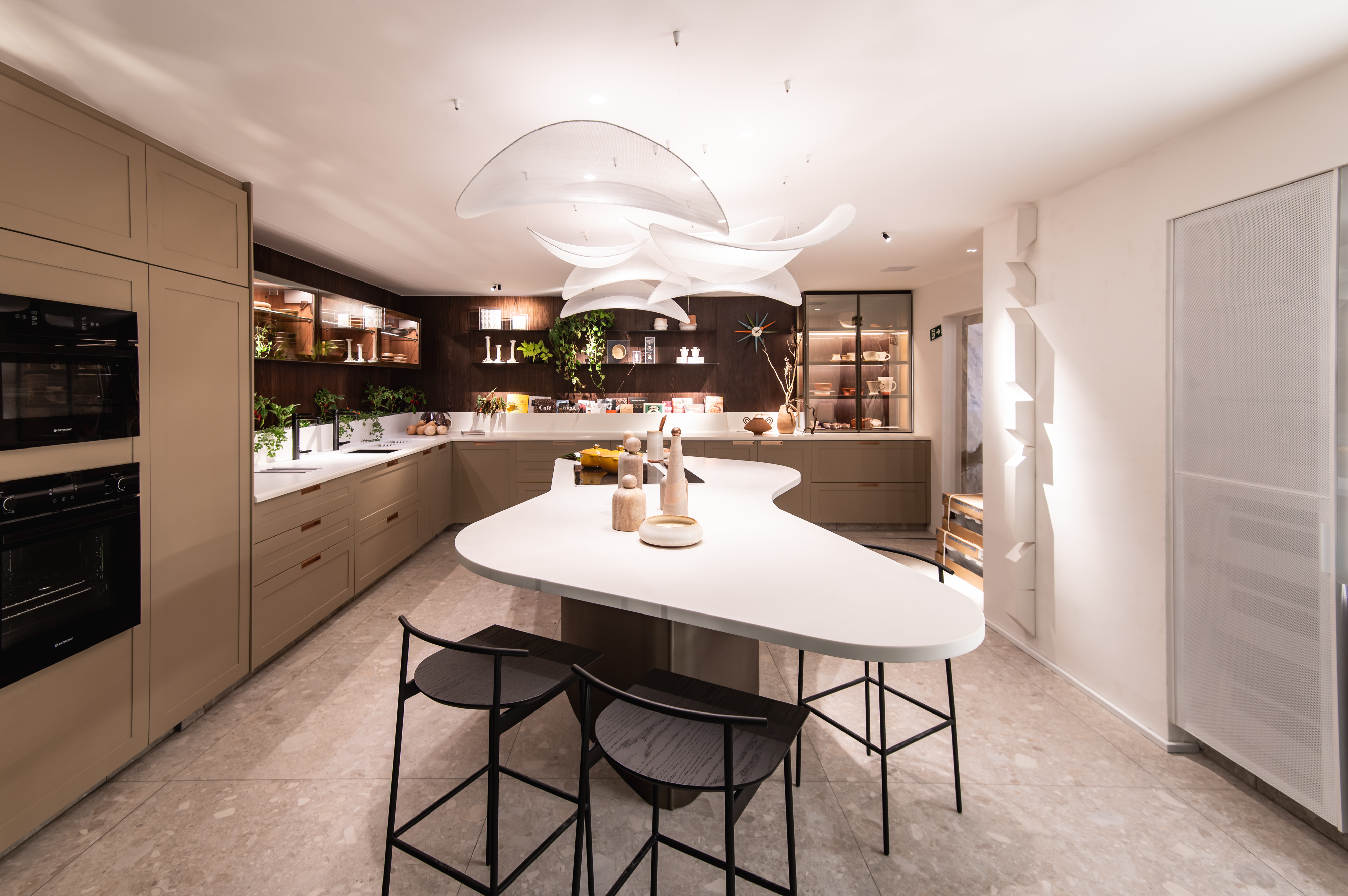 Susana Clark Fiuza - Cozinha Kitchens. Com um conceito moderno e inovador, o projeto de 42 m² destaca as qualidades da marca ao incorporar tendências internacionais e nacionais de design. Centralizado em uma ilha de Corian, a cozinha oferece sofisticação e acolhimento, impulsionando decisões projetuais. Materiais de alta qualidade, incluindo madeira natural e vidro, adicionam durabilidade e elegância. A proposta alinha-se ao tema da CASACOR Ceará deste ano, criando um espaço sofisticado e confortável para a convivência da família moderna.