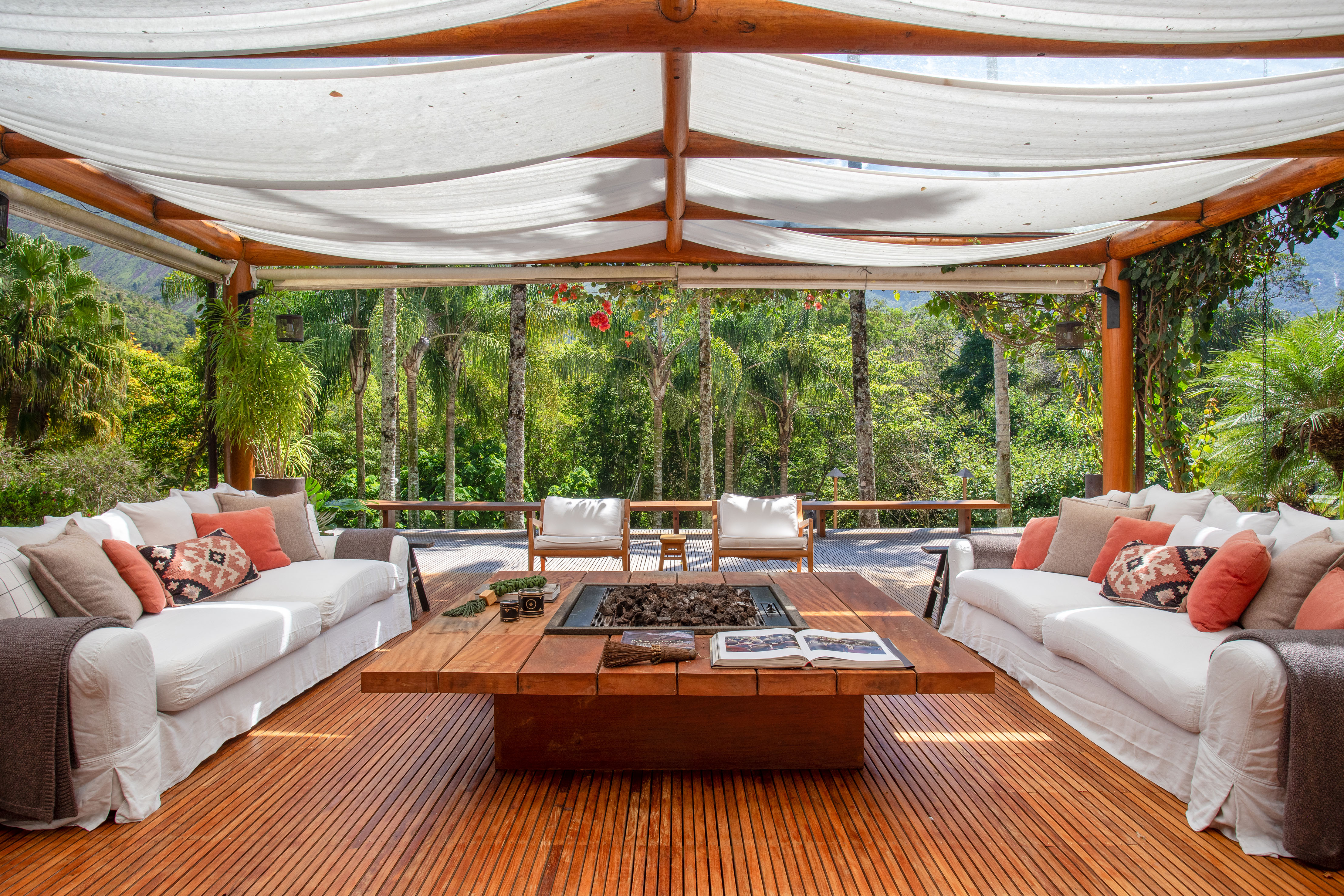 Marcela Martins assina retrofit de casa de campo do sócio-fundador da Farm. Na foto, varanda com sofá, mesa e vista para o jardim.